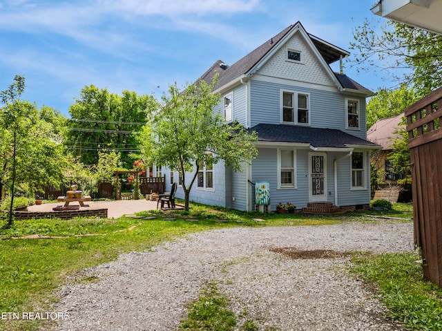 rear view of property featuring fence, a patio area, and a shingled roof