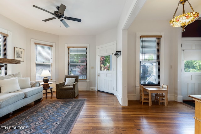living area with ceiling fan, wood finished floors, and baseboards