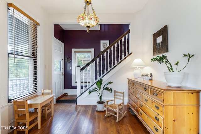 foyer featuring stairway, hardwood / wood-style flooring, and baseboards