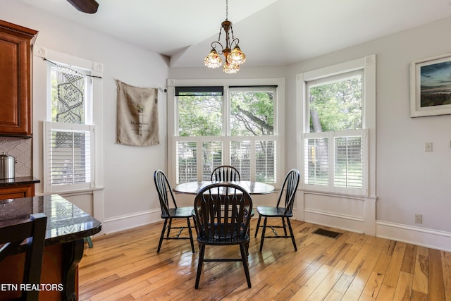 dining area with a notable chandelier, visible vents, baseboards, and light wood-type flooring