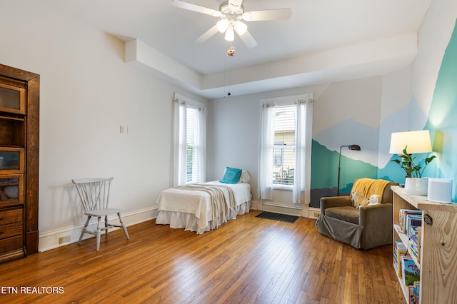 bedroom featuring ceiling fan, hardwood / wood-style flooring, and baseboards