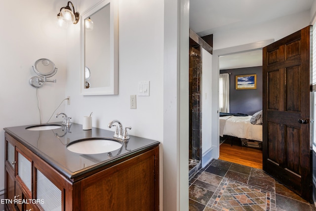 ensuite bathroom with double vanity, stone finish floor, ensuite bathroom, and a sink
