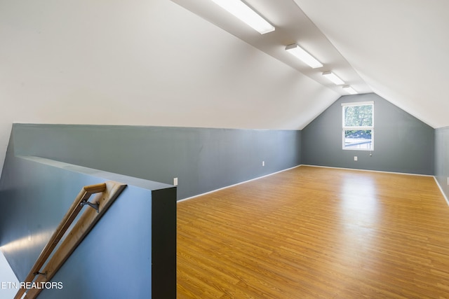bonus room featuring wood finished floors and vaulted ceiling