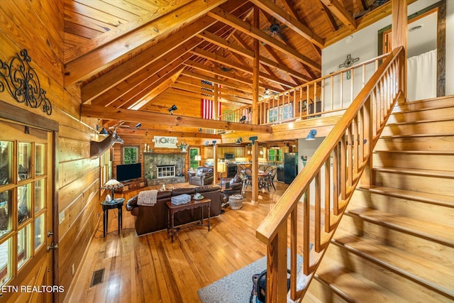 761 N Knob Creek Rd, Seymour, TN 37865 - living room with wood walls, hardwood / wood-style flooring, wooden ceiling with exposed beams, a fireplace, and stairway