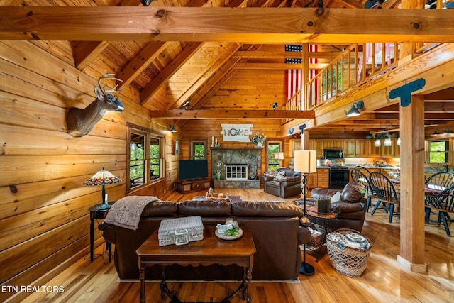 761 N Knob Creek Rd, Seymour, TN 37865 - living area with healthy amount of natural light, wood walls, high vaulted ceiling, light wood-style floors, and a stone fireplace
