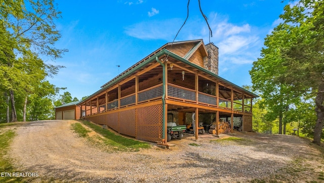 761 N Knob Creek Rd, Seymour, TN 37865 - rear view of property featuring driveway, a chimney, a detached garage, a deck, and an outbuilding