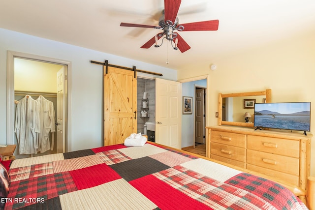 bedroom featuring a ceiling fan and a barn door