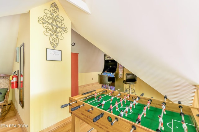playroom with baseboards, vaulted ceiling, and wood finished floors