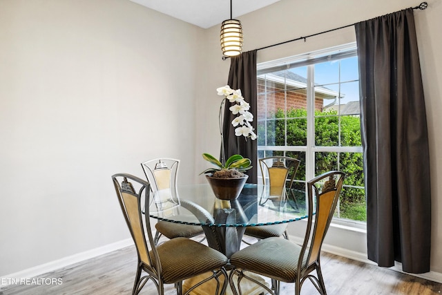 dining space with light wood-type flooring and baseboards