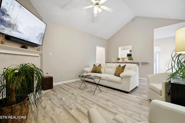 living room with high vaulted ceiling, baseboards, a ceiling fan, and light wood-type flooring