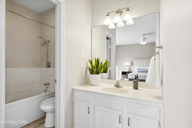 bathroom featuring toilet, wood finished floors, ceiling fan, vanity, and connected bathroom