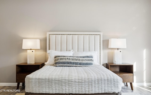 bedroom featuring wood finished floors and baseboards