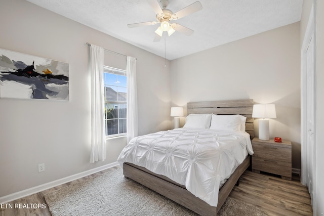 bedroom with ceiling fan, baseboards, and wood finished floors