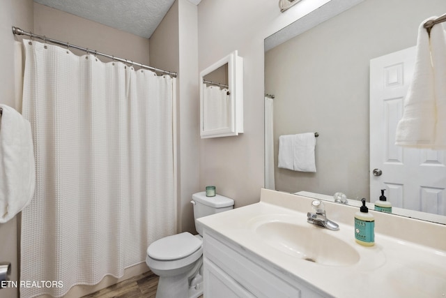 bathroom featuring a shower with curtain, wood finished floors, vanity, and toilet