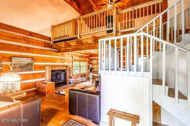 living area with a fireplace with raised hearth, wood finished floors, ceiling fan, stairway, and wood ceiling