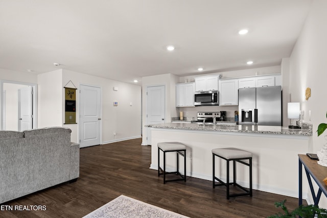 1423 Ridge Estates Dr, Athens, TN 37303 - kitchen featuring appliances with stainless steel finishes, light stone countertops, white cabinets, recessed lighting, and dark wood-style flooring