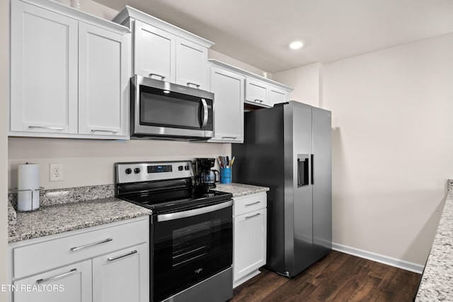 1423 Ridge Estates Dr, Athens, TN 37303 - kitchen with appliances with stainless steel finishes, dark wood-style flooring, white cabinets, light stone countertops, and baseboards