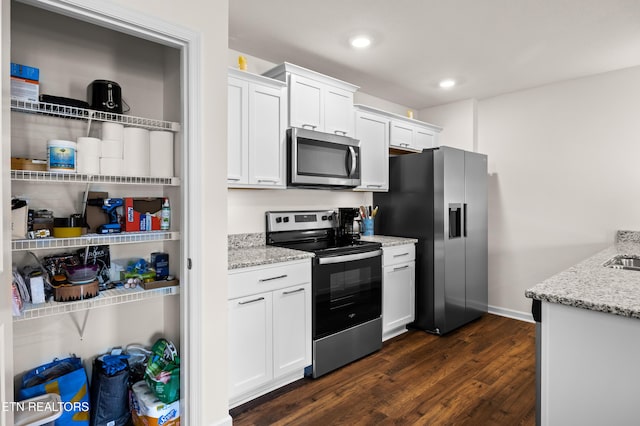 1423 Ridge Estates Dr, Athens, TN 37303 - kitchen with stainless steel appliances, dark wood-type flooring, light stone counters, white cabinetry, and recessed lighting
