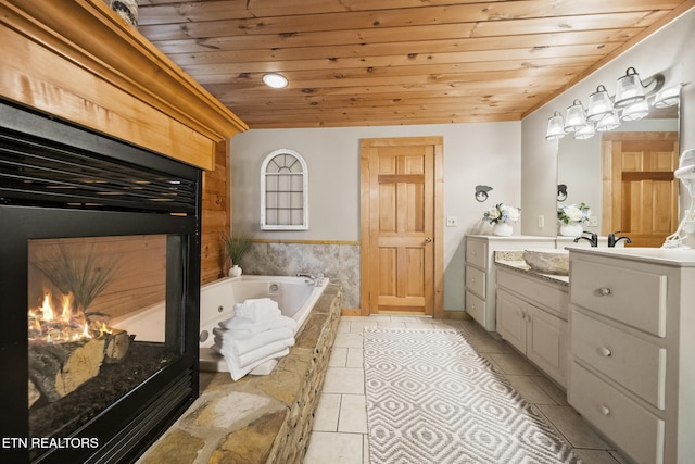 full bathroom featuring tile patterned flooring, vanity, a glass covered fireplace, wooden ceiling, and a bath