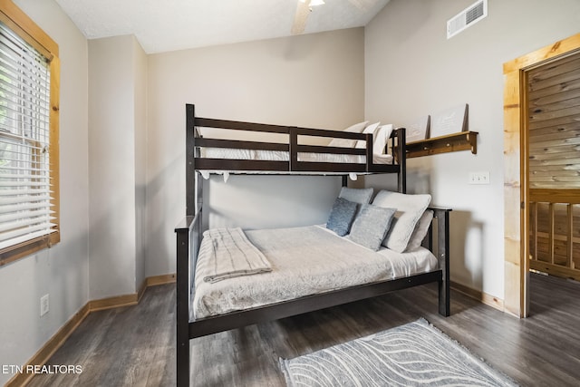 bedroom featuring baseboards, visible vents, and wood finished floors