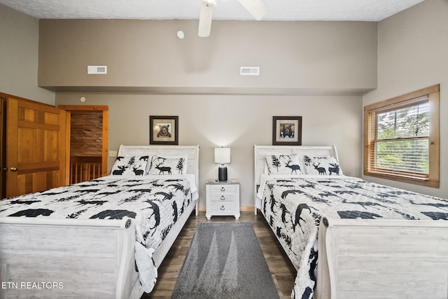bedroom with a ceiling fan, dark wood-style flooring, and visible vents