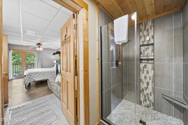ensuite bathroom featuring tile patterned floors, ceiling fan, a shower stall, and connected bathroom