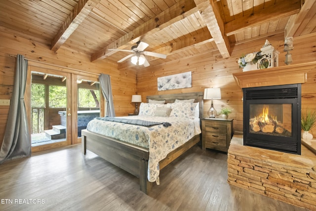 bedroom with wood walls, wood finished floors, and access to exterior