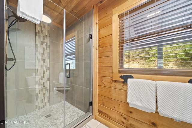 bathroom featuring tile patterned flooring, a stall shower, and a wealth of natural light