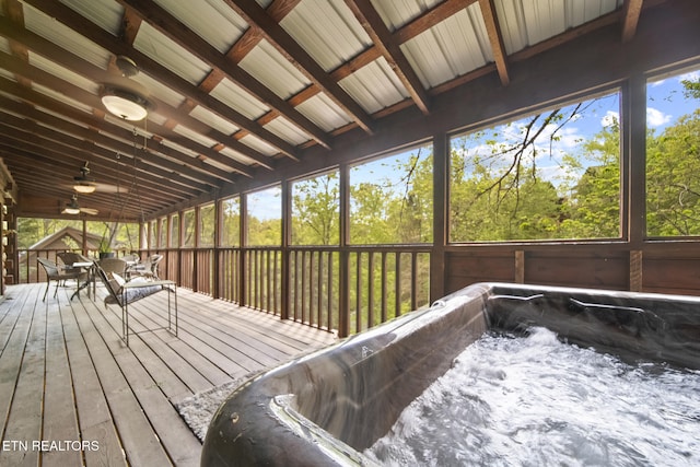 wooden deck with a ceiling fan, a hot tub, and outdoor dining space