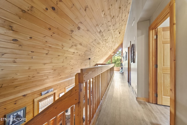 corridor featuring wood ceiling, wood finished floors, vaulted ceiling, and an upstairs landing