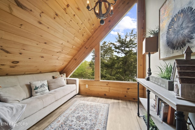 interior space with lofted ceiling, wood finished floors, wooden walls, wooden ceiling, and a notable chandelier