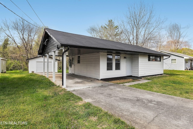view of front of house with an outdoor structure, driveway, and a front yard