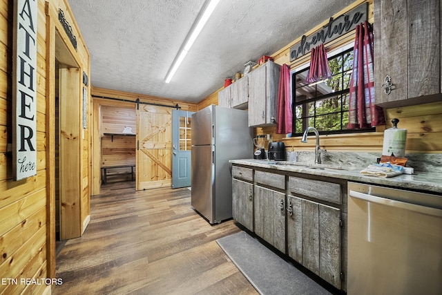 901 Sunrise Blvd, Sevierville, TN 37862 - kitchen featuring a textured ceiling, a barn door, a sink, light wood-style floors, and stainless steel appliances