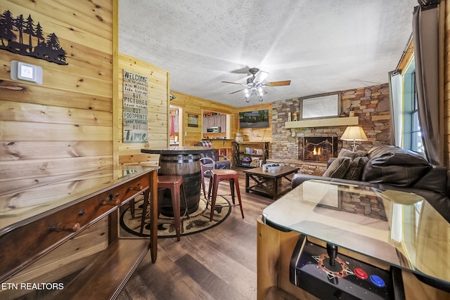901 Sunrise Blvd, Sevierville, TN 37862 - living area with wooden walls, a fireplace, a textured ceiling, a ceiling fan, and wood finished floors