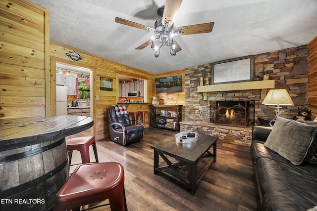901 Sunrise Blvd, Sevierville, TN 37862 - living area featuring a ceiling fan, a textured ceiling, a fireplace, wood walls, and wood finished floors