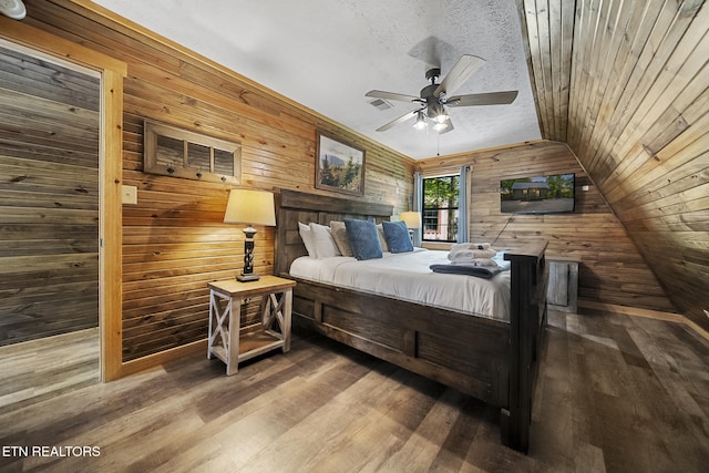 901 Sunrise Blvd, Sevierville, TN 37862 - bedroom featuring visible vents, wood finished floors, lofted ceiling, wooden walls, and a textured ceiling