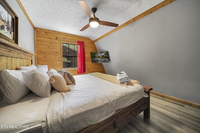 901 Sunrise Blvd, Sevierville, TN 37862 - bedroom with wood finished floors, lofted ceiling, ceiling fan, wooden walls, and a textured ceiling