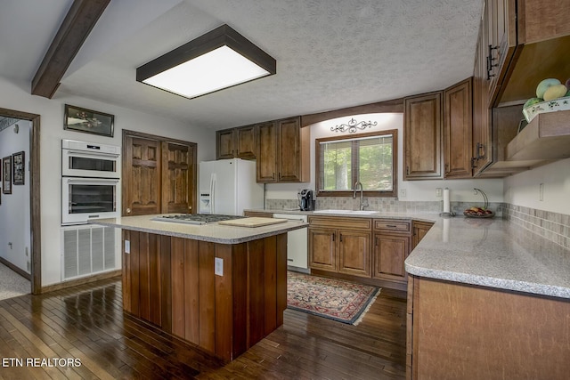 kitchen with open shelves, a sink, white refrigerator with ice dispenser, dark wood finished floors, and dishwashing machine