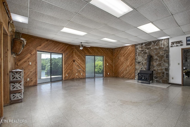 unfurnished living room featuring a healthy amount of sunlight, light floors, and a wood stove