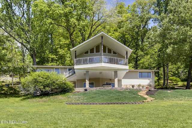 back of house with a lawn and a balcony