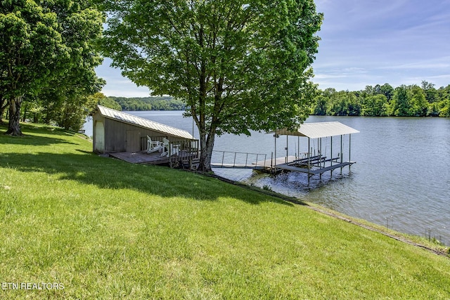 dock area with a water view, a yard, and boat lift