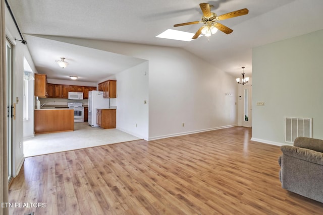 11 Windsor Pt, Crossville, TN 38558 - unfurnished living room with light wood-style floors, ceiling fan with notable chandelier, baseboards, visible vents, and lofted ceiling with skylight