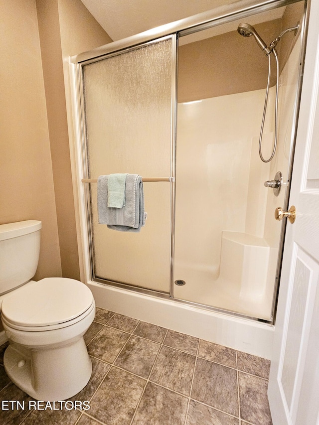 full bath featuring a stall shower and toilet