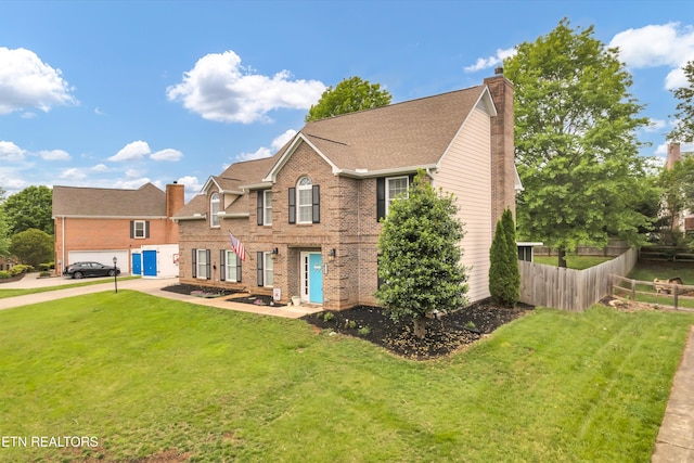 view of front facade with brick siding, fence, a chimney, and a front yard