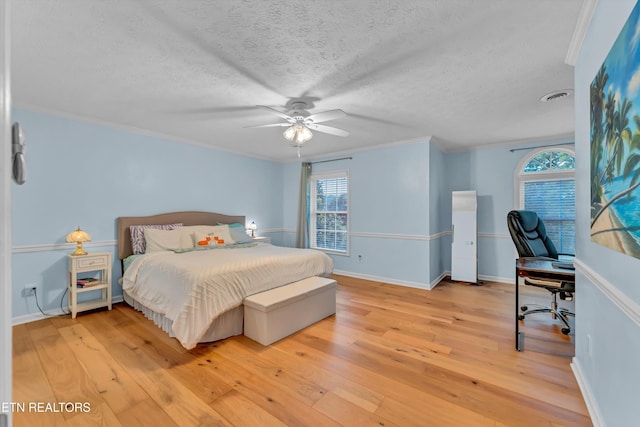 bedroom featuring crown molding, light wood-style flooring, and a ceiling fan