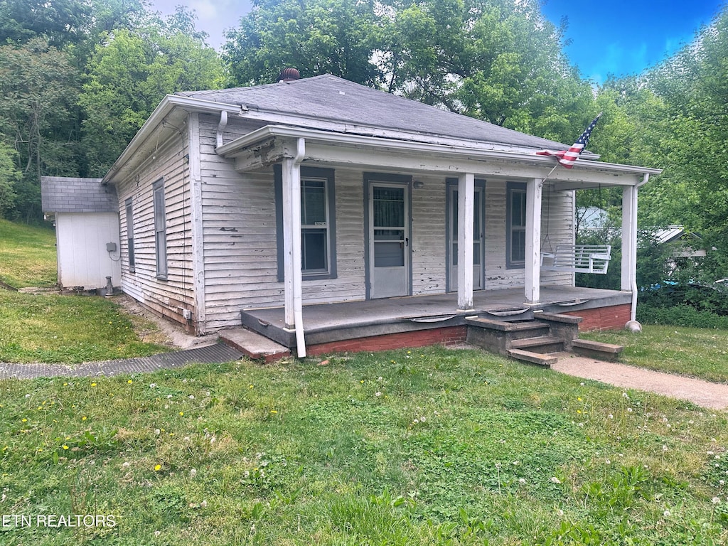 bungalow-style home with a porch and a front lawn