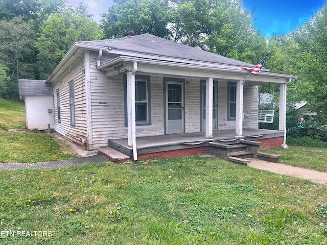 bungalow-style home with a porch and a front lawn