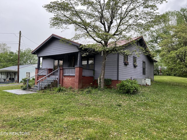 922 W Central Ave, Lafollette, TN 37766 - view of front facade featuring central AC, a front lawn, and covered porch