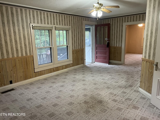 922 W Central Ave, Lafollette, TN 37766 - spare room featuring wallpapered walls, visible vents, ceiling fan, and wainscoting
