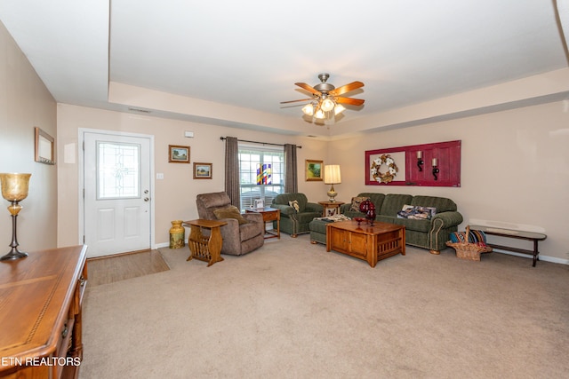 living room with a ceiling fan, light carpet, and baseboards